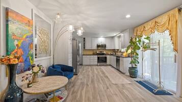 A modern kitchen with white cabinets, stainless steel appliances, and a central island.