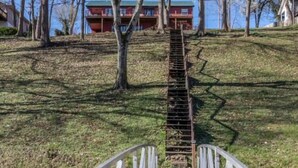 A wooden bridge with white railings leading to a building with a red roof. - Enjoy fireside sunset & walk to movies, shops, restaurants! (Winchester)