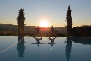 Een seizoensgebonden buitenzwembad, ligstoelen bij het zwembad