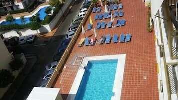 Een buitenzwembad en ligstoelen