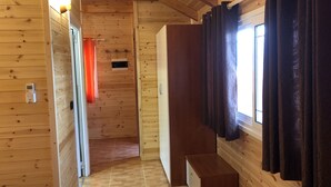 Een houten interieur met een bank, een deur en een raam met gordijnen.
