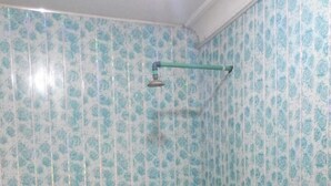 Une salle de bain comprenant des toilettes, un lavabo et un espace douche.
