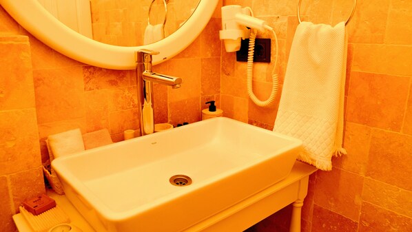 A bathroom with a white sink, a mirror, a towel rack, and a toilet paper holder. - Casa Rubino Alacati (Cesme)