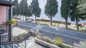 A residential area with a road, trees, and a body of water in the background. - Modern Apartment "Gennaker" On Lakeside with Terrace and View (Malcesine)