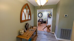 A hallway with a wooden bench, a mirror, and a ceiling light fixture. - She's back! Under new management (Cullman)
