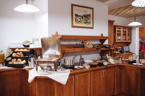 Un buffet proposant divers plats, une machine à café et un tableau accroché au mur.