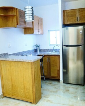 Full-sized fridge, stovetop, cookware/dishes/utensils