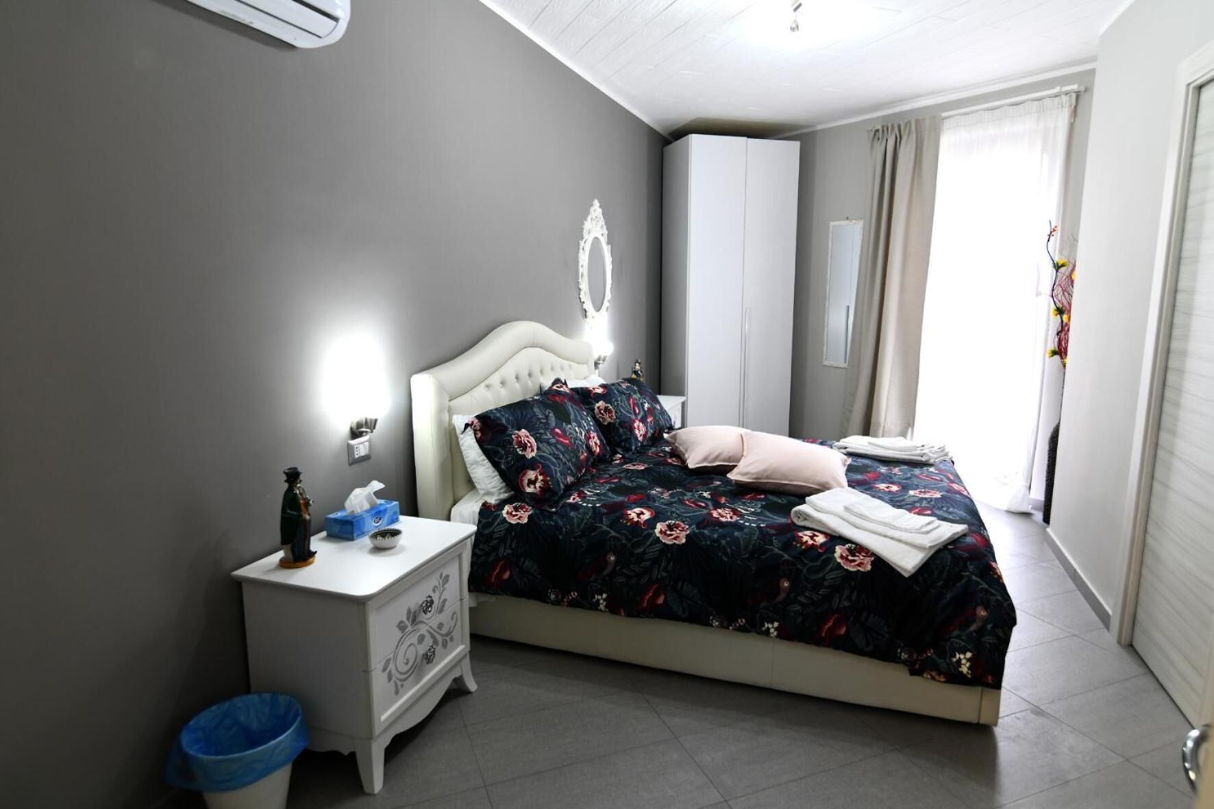 A bedroom with a bed, bedside table, and a nightstand.