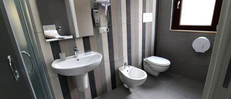 Un baño moderno con bidé, inodoro y lavamanos.