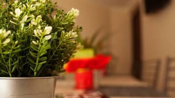 A potted plant with green leaves and white flowers in a metal pot.