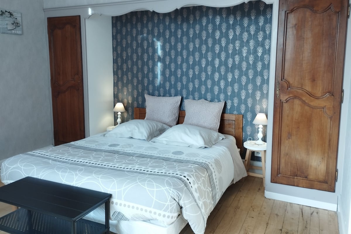 Ein Schlafzimmer mit einem Bett, zwei Nachttischen, einem Schrank und einem Holzschrank.