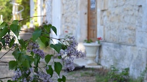 A stone building with a wooden door and a small porch. - Villa du Cerf Thibault (Le Blanc)