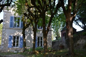 A building with two windows and a door, surrounded by trees. - Villa du Cerf Thibault (Le Blanc)