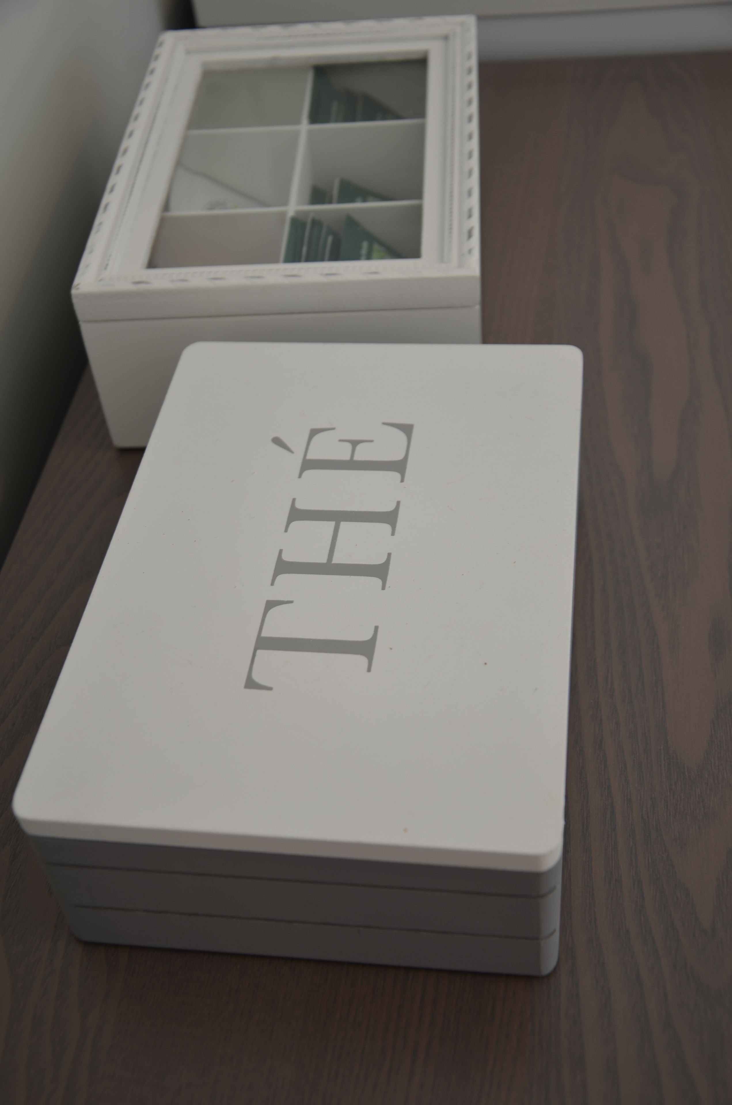 Una caja blanca con la palabra "THE" sobre una superficie de madera.