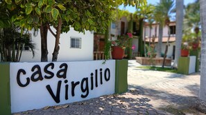 A sign for 'Casa Virgilio' with a paved pathway and greenery in the background.