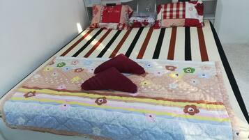 Cozy retreat with a neatly made bed, striped bedspread, and floral quilt.
