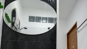 A bathroom with a white sink, a mirror, and a shower. - Sroe Ground Homestay (Sanom)