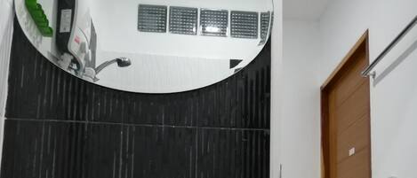 A bathroom with a white sink, a mirror, and a shower.