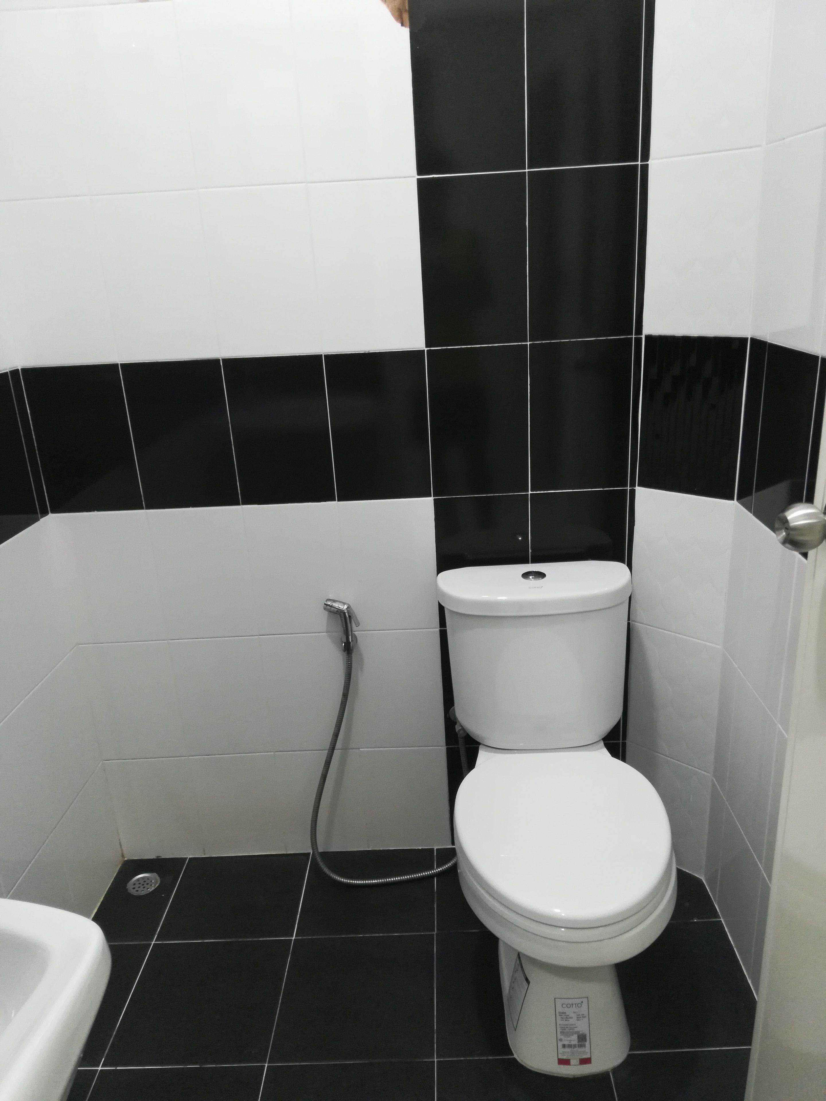 A bathroom with a toilet, a shower, and a sink.