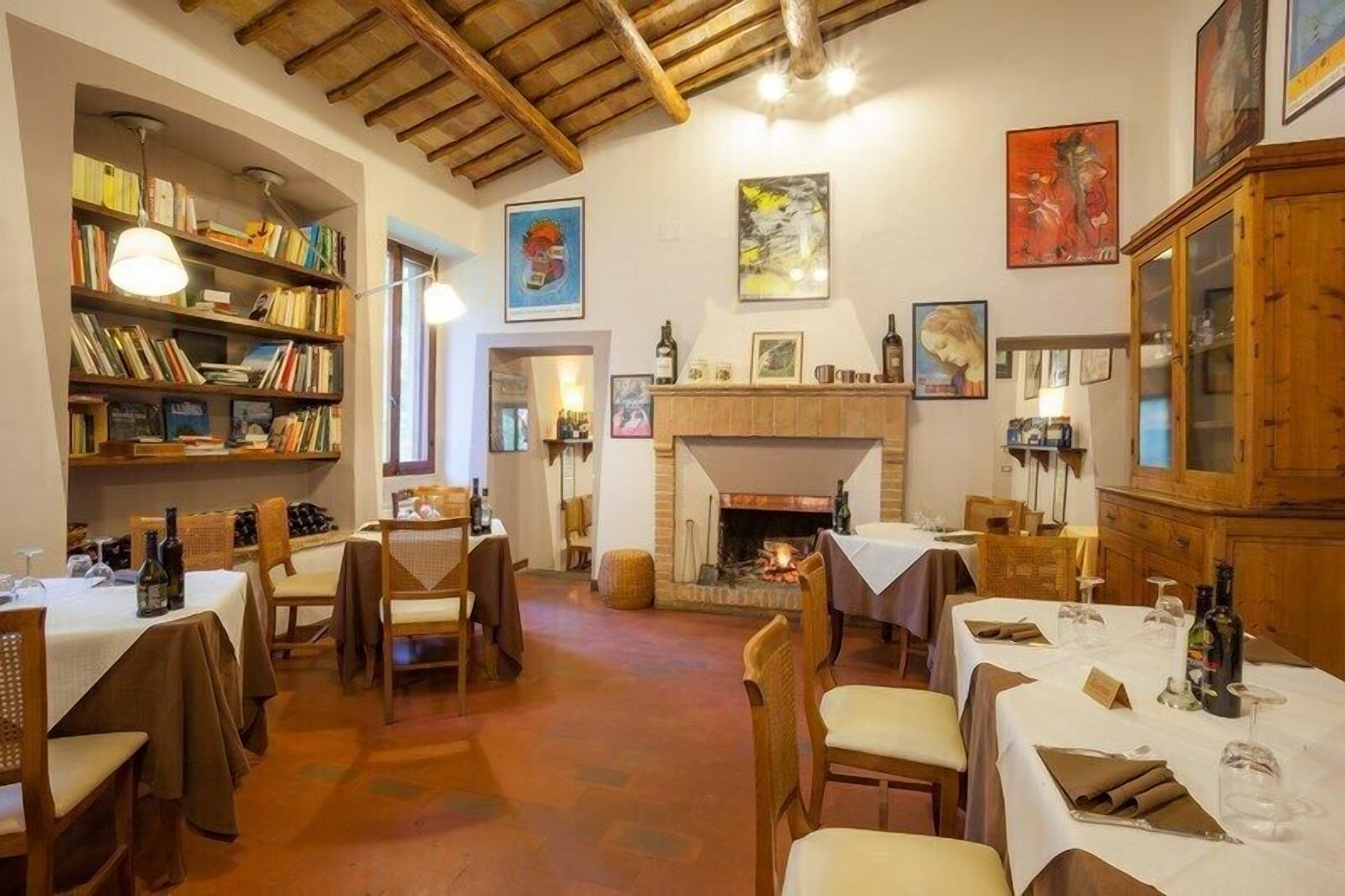 Un'accogliente zona pranzo con tavoli e sedie in legno e un camino.