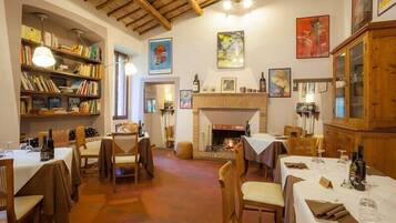 Un'accogliente zona pranzo con tavoli e sedie in legno e un camino.