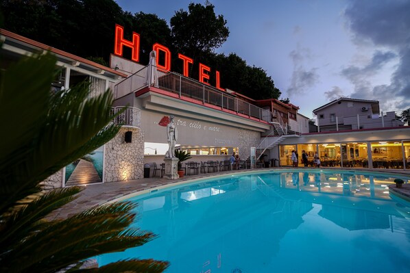 A hotel with a swimming pool, outdoor seating, and a staircase leading to the entrance. - Hotel Orizzonte Blu di Tropea (Ricadi)