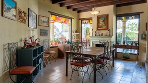 A dining area with a wooden table and chairs, a blue shelving unit, and various decorative items.