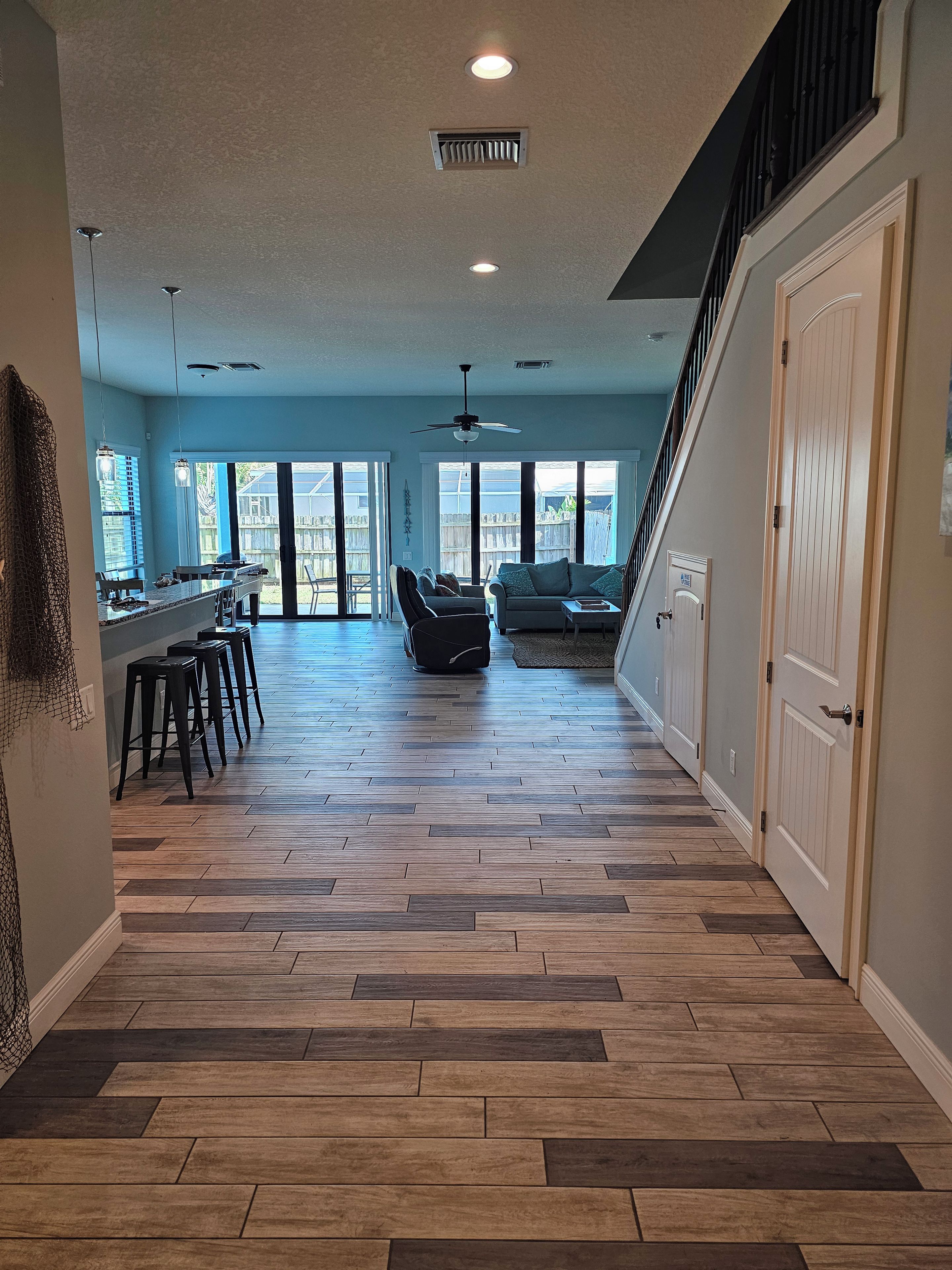 A spacious interior with a kitchen area, dining space, and a staircase leading to another level.