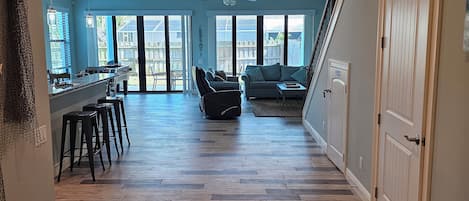 Un interior espacioso con área de cocina, comedor y una escalera que conduce a otro nivel.