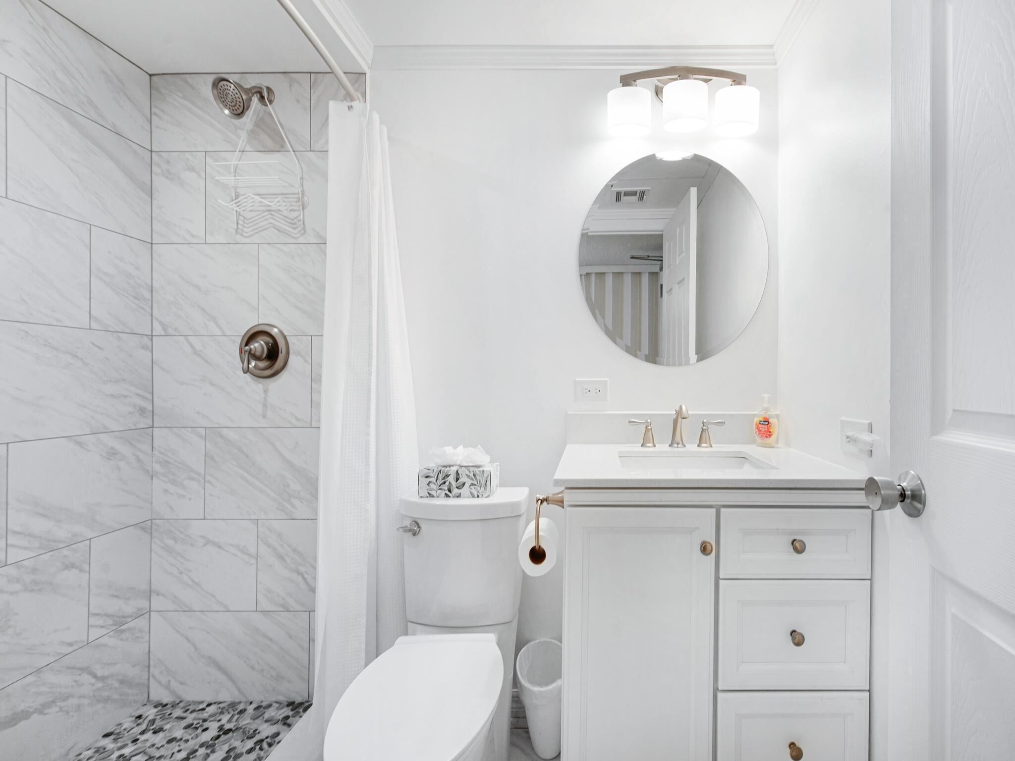 Un baño moderno con inodoro, lavamanos y ducha.