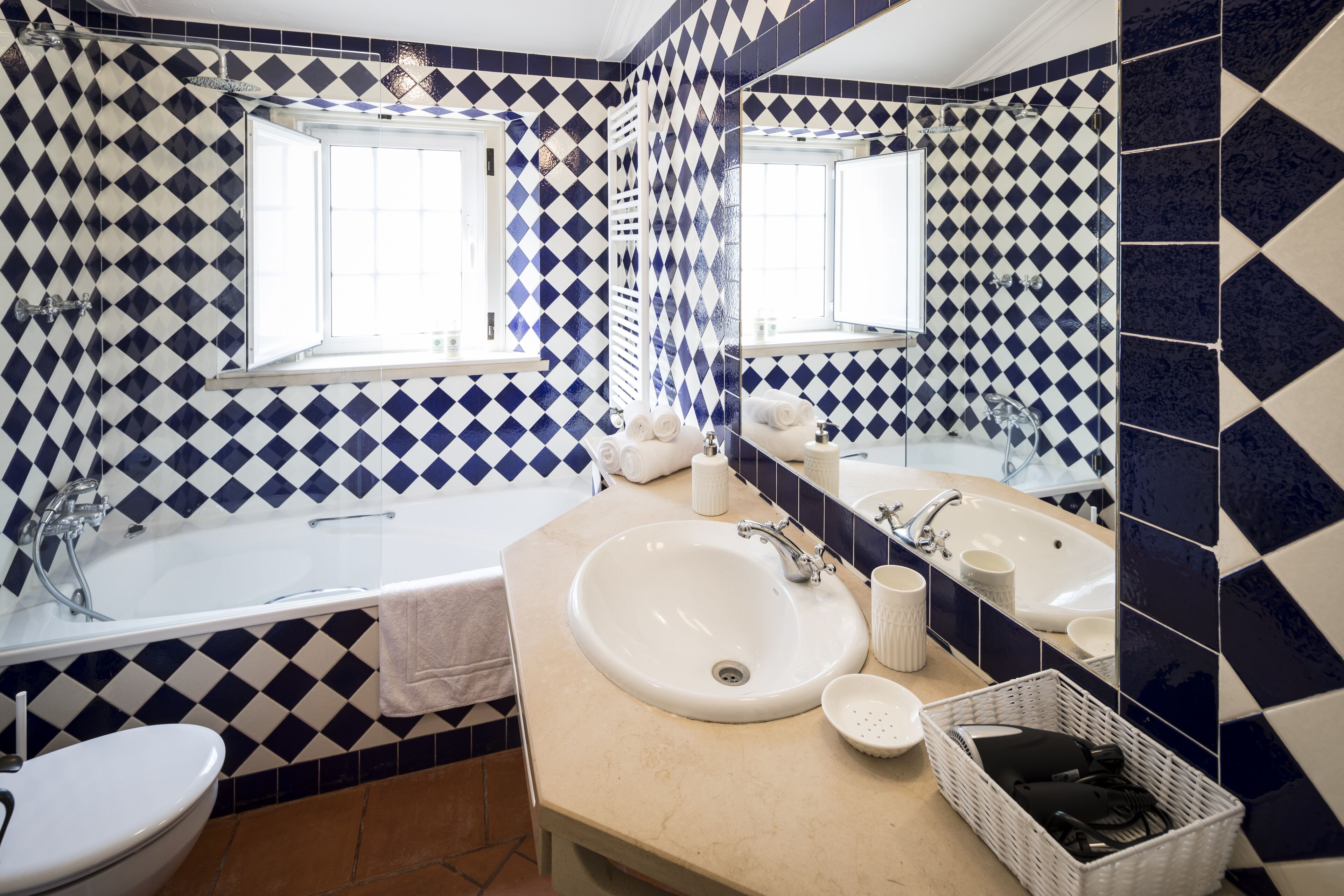 A bathroom with a large bathtub, two sinks, and a mirror.