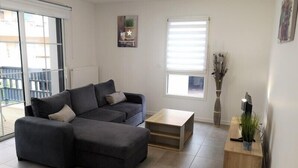 A modern living room with a sectional sofa, a small coffee table, and a side table with a plant.