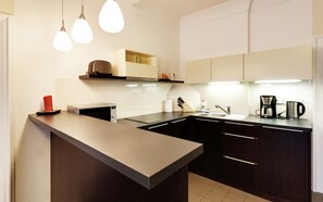 Apartamento superior, 2 quartos | Cozinha privada | Geladeira, cooktop, cafeteira/chaleira, cadeirão de bebê