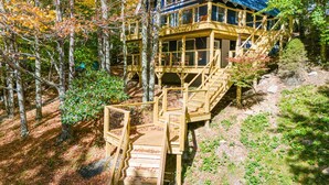 A wooden cabin with a blue roof, surrounded by trees and a wooden deck. - Renovated, Foosball, In the trees, EV charger! (Beech Mountain)