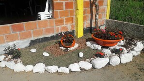 A garden area with potted plants and white rocks arranged in a decorative pattern. - Enjoy nature in a chalet with a pool, just 200m from the best beach in Ubatuba. (Ubatuba)