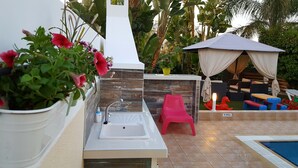 A bathroom with a sink, a shower, and a small seating area with a chair and a table. - Villa With Private Pool, Sea View With Grass And 2 Gazebos (Pernera)