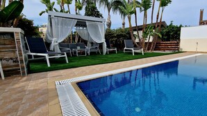 A swimming pool with lounge chairs and a covered seating area. - Villa With Private Pool, Sea View With Grass And 2 Gazebos (Pernera)