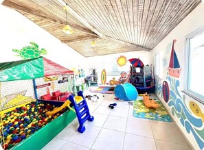 A playroom with a ball pit, climbing area, and a mural with nautical themes. - Luxury 3-Bedroom Beachfront Apartment | Sleeps 10. (Praia Grande)
