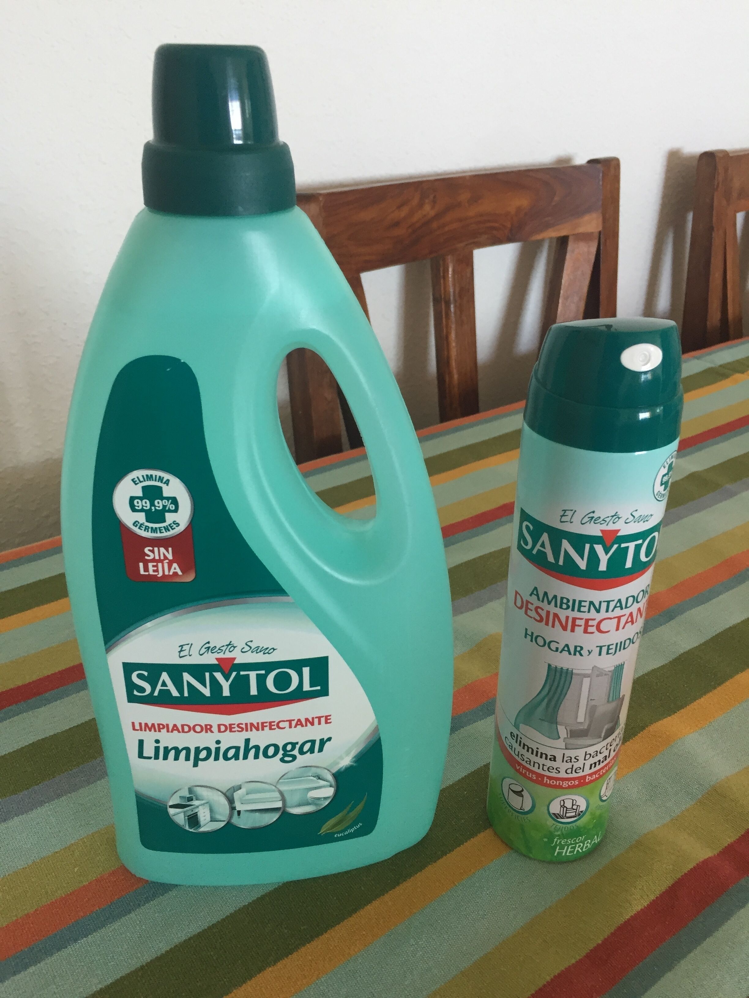 Two bottles of Sanytol cleaning products on a striped tablecloth.