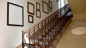 A staircase with ornate metal railings and framed pictures on the wall. - PANORAMA Apartment - Large lake view apartment, 2 rooms, 4 places (Solto Collina)