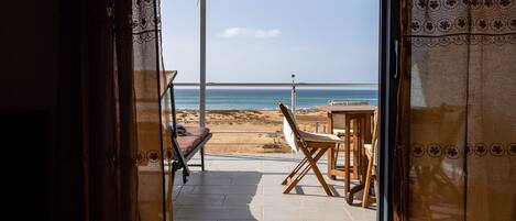 Relax on the beachfront terrace with a view, featuring a table and two chairs.