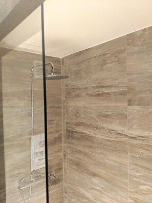 Een douche, handdoeken, zeep, toiletpapier