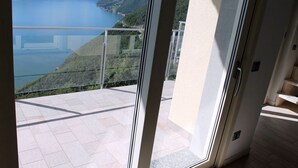 Un balcon avec vue sur un lac et des collines.