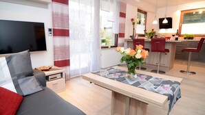 Ein modernes Wohnzimmer mit einer Couch, einem Couchtisch und einem Fernseher.