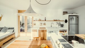 Une cuisine moderne dotée d’un îlot central, d’un four encastré et d’un réfrigérateur en acier inoxydable.