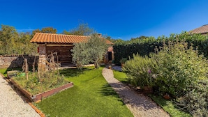 A rustic stone building with a tiled roof, surrounded by a well-maintained garden with a gravel path. - Holiday house NOVKOVIC with garden (Žgaljići)