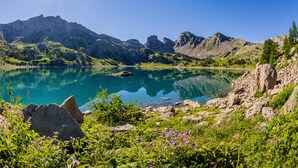 A mountain lake with clear turquoise water, surrounded by rocky terrain and greenery. - Duplex apartment 4/5 people at the foot of the slopes. Serre chevalier 1500 (Le Monêtier-Les-Bains)