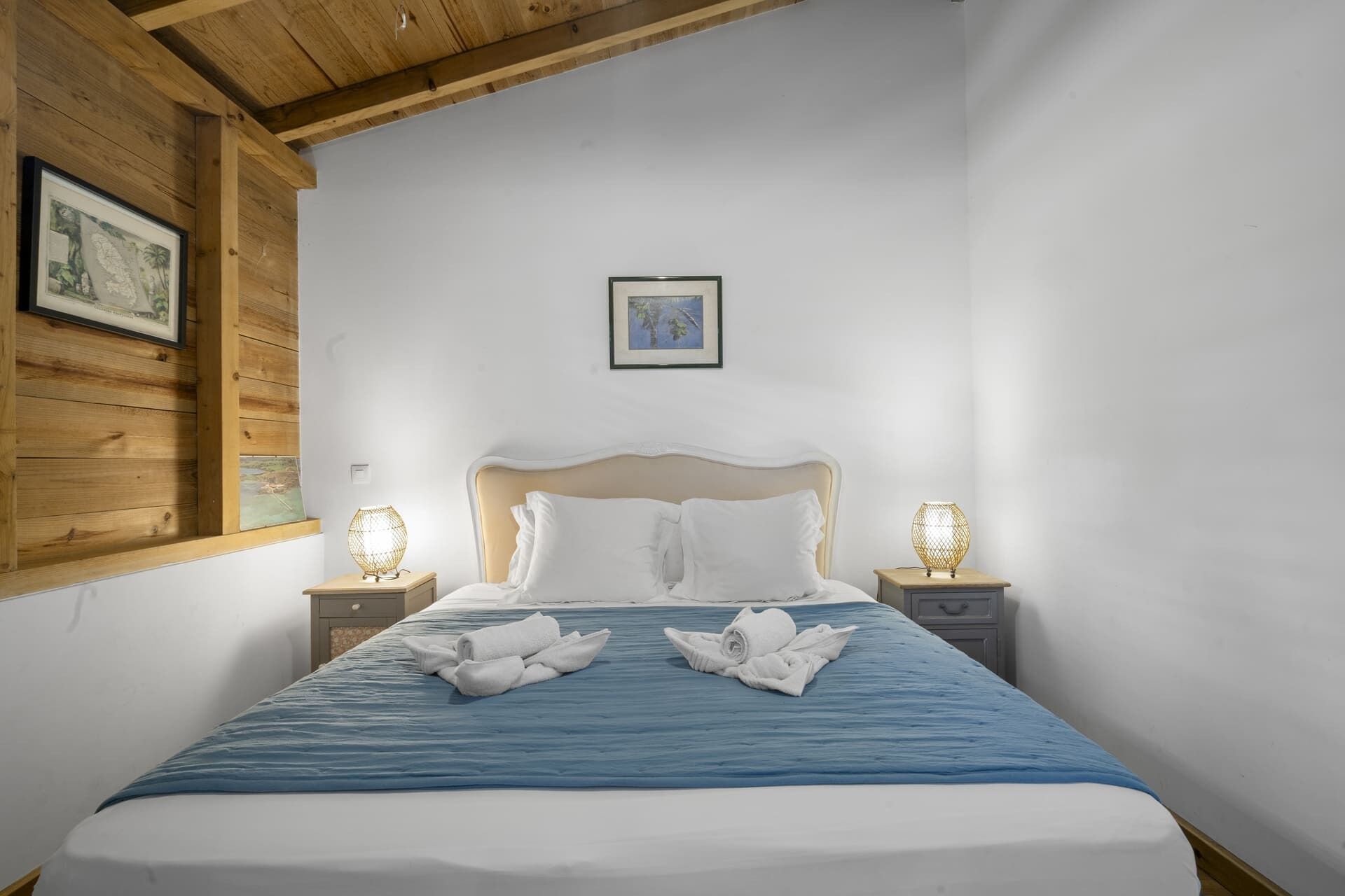 Une chambre à coucher avec un lit, deux tables de chevet et un plafond en bois.