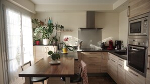Una cucina moderna con mobili in legno, cappa aspirante in acciaio inossidabile ed elettrodomestici integrati, tra cui un forno a microonde e un forno.