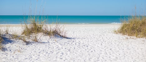 Una playa cerca, sillas reclinables de playa, toallas de playa